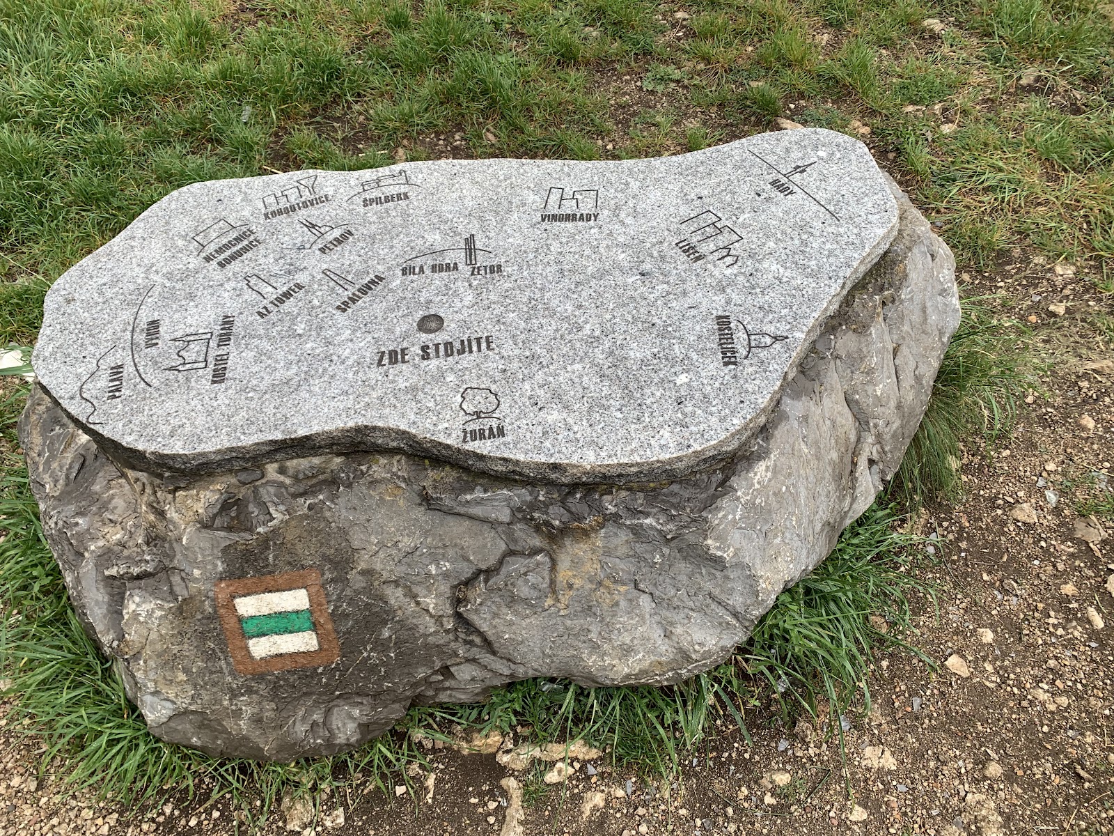 Kamenná mapa s vyznačenými body a turistickou značkou.